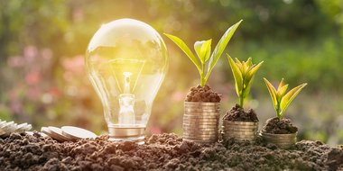 Symbolbilder für nachhaltige Ideen – mit Lampe und Geldstapeln